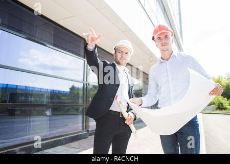 Vista di un ingegnere e lavoratore piano di controllo sul sito in costruzione. affare, appartamento acquisto, real estate Foto Stock