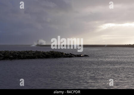 Moody ampia vista della voce del romantico fiume Ave, Portogallo, Vila do Conde (vicino al porto), poco prima del tramonto vedendo alcuni onde tempestose contro paglierino Foto Stock