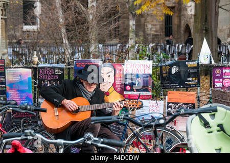 Un suonatore ambulante di suonare una chitarra in St John's Street, Cambridge. Foto Stock