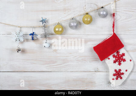 Le palle di Natale , il calzino e albero di Natale con una stella appeso a una fune. bianco sullo sfondo a chiazze. Foto Stock