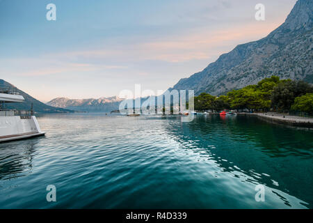 La mattina presto come sole sorge sulle montagne e acque verde smeraldo della Baia di Kotor, Montenegro. Foto Stock
