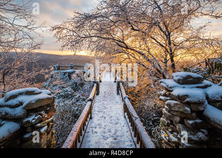 Il percorso che conduce alla principale si affacciano a Coopers Rock State Forest in West Virginia è coperto di neve e ghiaccio, Sun offre un caldo aga retroilluminazione Foto Stock