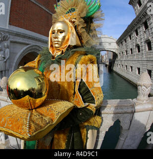 Venezia, VE, Italia - 5 Febbraio 2018: uomo mascherato con il Golden Globe e il Ponte dei Sospiri anche chiamato Ponte dei Sospiri in lingua italiana Foto Stock