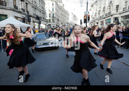 L'elite di canzone e ballo truppa "Il West End Kids', esecuzione di brani dal 'Torna a lui futuri film, di fronte alla DeLorean Time Machine Foto Stock