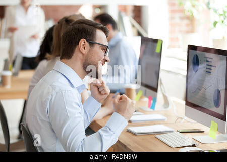 Happy businessman guardando lo schermo, clenching a suon di pugni Foto Stock