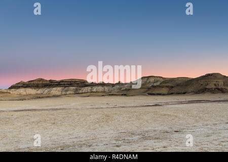 Il paesaggio del deserto e le colline del Bisti Badlands del Nuovo Messico al tramonto sotto un bel cielo con rosa, pesche, viola e le sfumature di blu Foto Stock