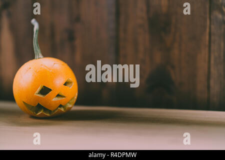 Primo piano del Bambino scolpita la zucca sullo sfondo botte Foto Stock