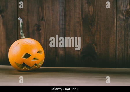 Primo piano del Bambino scolpita la zucca sullo sfondo botte Foto Stock