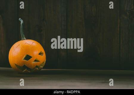 Primo piano del Bambino scolpita la zucca sullo sfondo botte Foto Stock