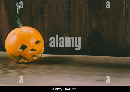 Primo piano del Bambino scolpita la zucca sullo sfondo botte Foto Stock