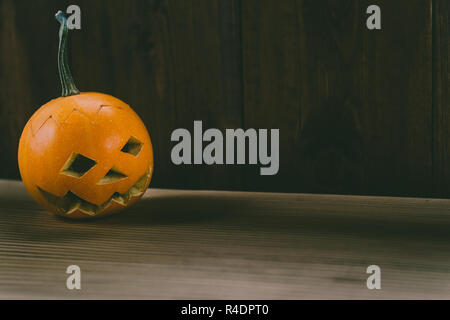 Primo piano del Bambino scolpita la zucca sullo sfondo botte Foto Stock