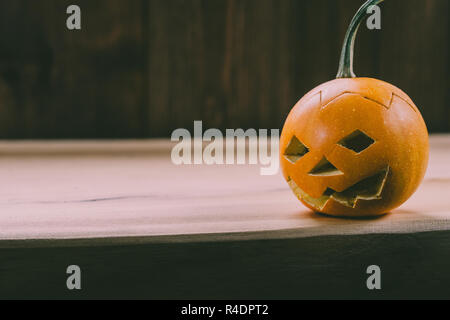 Primo piano del Bambino scolpita la zucca sullo sfondo botte Foto Stock