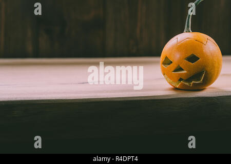 Primo piano del Bambino scolpita la zucca sullo sfondo botte Foto Stock