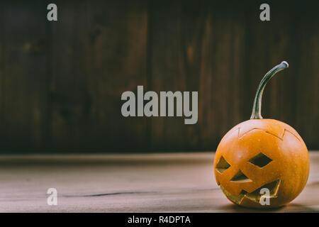 Primo piano del Bambino scolpita la zucca sullo sfondo botte Foto Stock