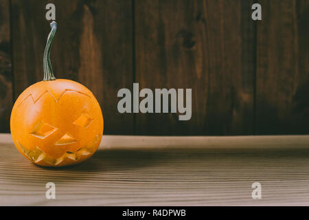 Primo piano del Bambino scolpita la zucca sullo sfondo botte Foto Stock