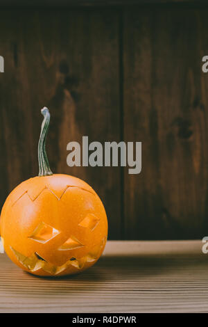 Primo piano del Bambino scolpita la zucca sullo sfondo botte Foto Stock