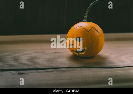 Primo piano del Bambino scolpita la zucca sullo sfondo botte Foto Stock