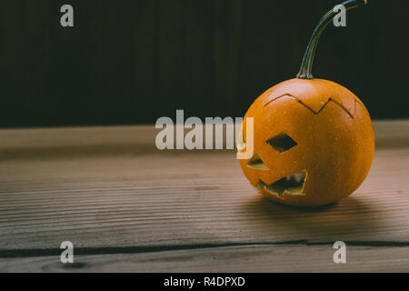 Primo piano del Bambino scolpita la zucca sullo sfondo botte Foto Stock