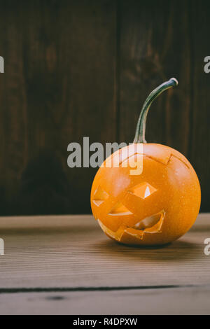 Primo piano del Bambino scolpita la zucca sullo sfondo botte Foto Stock