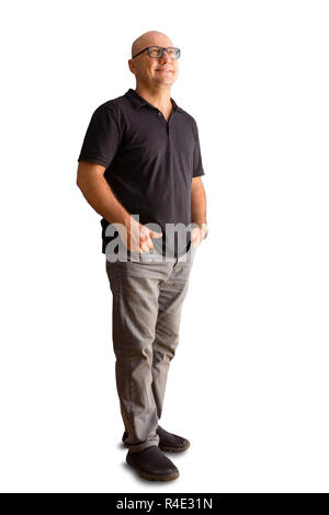 Sorridendo rilassato bald uomo di mezza età in tempo libero in piedi con le mani in tasca felicemente sorridente come egli guarda in alto sull'aria isolate su whi Foto Stock