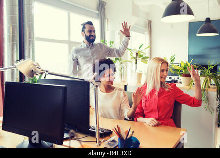 Happy team creative sventolare le mani in office Foto Stock