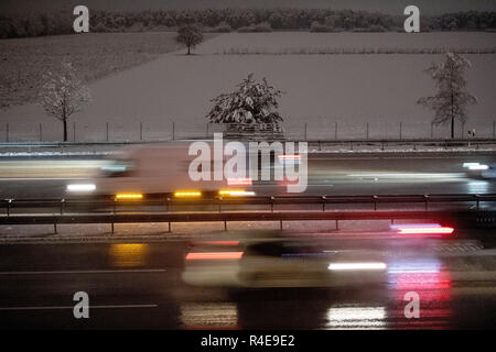 27 novembre 2018, Baviera München: sulla A9, auto guidare lungo coperta di neve alberi (più lungo tempo di esposizione). La prima neve di questo inverno è sceso in Baviera. Foto: Lino Mirgeler/dpa Foto Stock