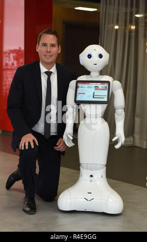 Bremen, Germania. Xvi Nov, 2018. Alexander Löde, capo del distretto ramo della Sparkasse Bremen-Neustadt, siede accanto al robot 'Luna Pepe'. Il robot dovrebbe accogliere i clienti, il loro supporto e chiacchierare un po' con loro. Credito: Carmen Jaspersen/dpa/Alamy Live News Foto Stock