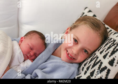 Sorridente ragazza distesa sul lettino con la sua sorella baby Foto Stock