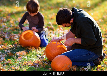 Padre e figlio carving zucche di Halloween, Stati Uniti Foto Stock