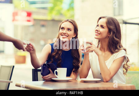 Le donne con carta di credito per pagare il caffè al caffè Foto Stock