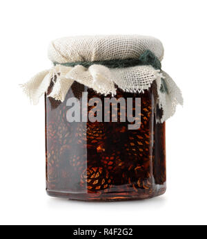 Il vasetto di vetro del cono di pino jam isolato su bianco Foto Stock