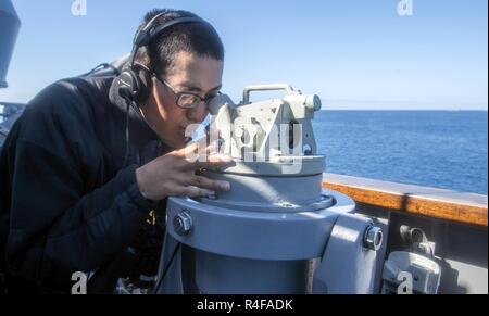 Oceano Pacifico (ott. 25, 2016) marinaio Dillon Nguyen utilizza un alidada per trovare il cuscinetto della Ticonderoga-class guidato-missili cruiser USS Lake Champlain (CG 57) dal ponte di porta ala. Lake Champlain è in corso composito conduttore unità di addestramento esercizio in preparazione per una futura installazione. Foto Stock