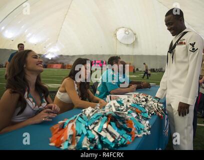 MIAMI (3 maggio 2017) Miami Dolphins cheerleaders firmare autografi per elettricista in mate 3° classe Asiedu Giona, nativo del Ghana, mentre visitano il team di training facility come parte della ventisettesima edizione della Settimana della flotta Port Everglades. Settimana della flotta Port Everglades fornisce un opportunità per i cittadini della Florida del sud di testimoniare di prima mano le funzionalità più recenti di oggi i servizi marittimi e acquisire una migliore comprensione di come il mare servizi supporto la difesa nazionale degli Stati Uniti. Foto Stock