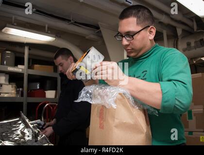 Pacifico occidentale (2 maggio 2017) specialista della logistica marinaio Jesse Ruiz, di San Antonio, nastri un pacchetto a bordo della Nimitz-class portaerei USS Carl Vinson (CVN 70). Gli Stati Uniti Marina ha pattugliato il Indo-Asia-Pacifico di routine per più di 70 anni regionale di promozione della pace e della sicurezza. Foto Stock