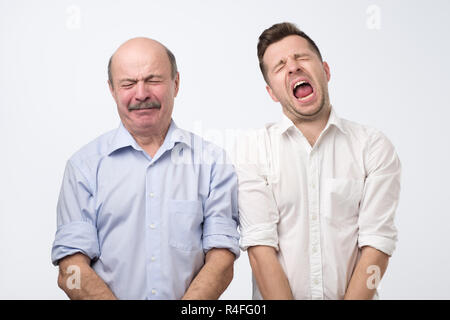 Ritratto dell'uomo è il pianto isolato su sfondo grigio Foto Stock