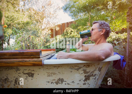 Uomo maturo di bere il caffè nella vasca da bagno Foto Stock