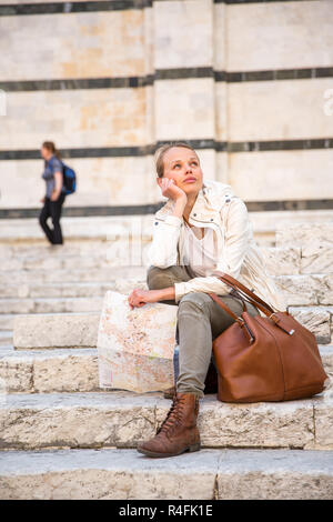 Bellissima femmina turistico con una mappa alla scoperta di una città estera (SHALLOW DOF dai toni di colore immagine) Foto Stock