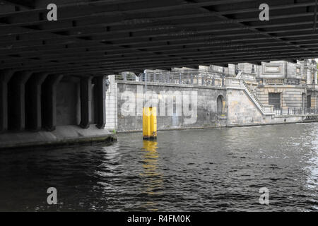 Giallo marcatura fairway nella parte anteriore del grigio di un muro di pietra sotto un ponte nel fiume Sprea a Berlino, Germania, spazio di copia Foto Stock