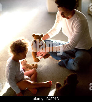 Madre e figlio giocare con orsetti di peluche Foto Stock