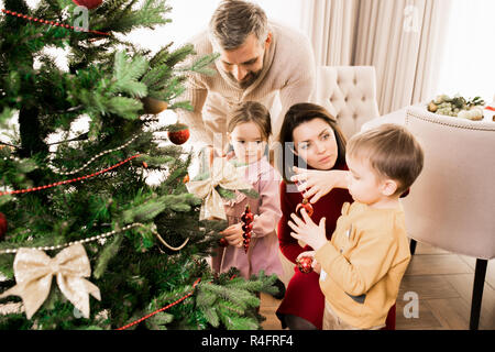 Famiglia decorare albero di Natale Foto Stock