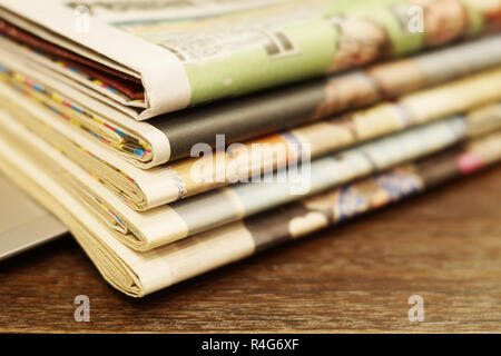 Pila di mattina freschi quotidiani sul tavolo in ufficio. Ultime notizie finanziarie ed economiche nel quotidiano. Le pagine con i dati. Piegato e riviste impilati Foto Stock
