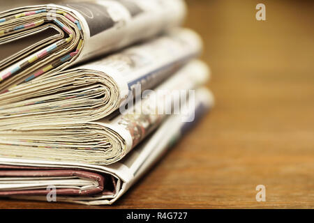 Pila di mattina freschi quotidiani sul tavolo in ufficio. Ultime notizie finanziarie ed economiche nel quotidiano. Le pagine con i dati. Piegato e riviste impilati Foto Stock