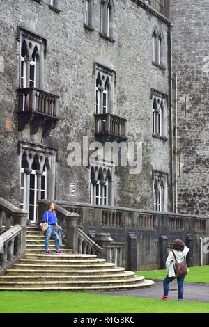 Le ragazze di scattare foto su scale davanti al muro di pietra del Castello di Kilkenny. Foto Stock