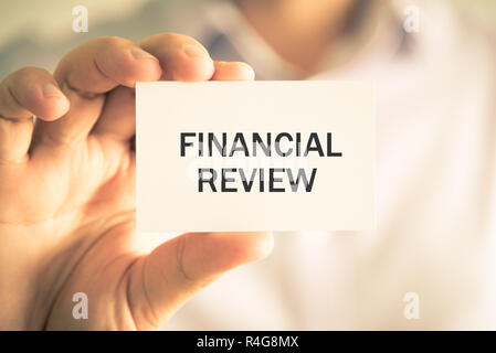 Businessman holding finanziaria messaggio di revisione card Foto Stock