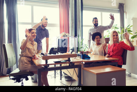 Happy team creative sventolare le mani in office Foto Stock