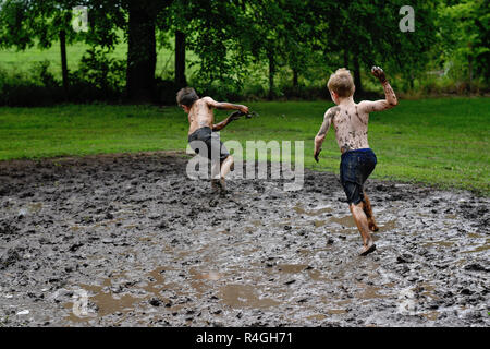 Due ragazzi gettare fango e combattere in una lotta di fango nel paese Foto Stock