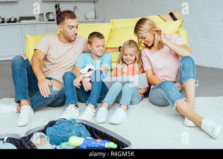 La famiglia felice spendendo molto tempo insieme durante l'imballaggio per le vacanze estive, il concetto di viaggio Foto Stock