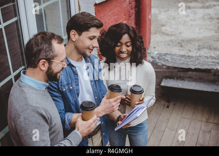Multietnica colleghi parlare di lavoro e un caffè Foto Stock