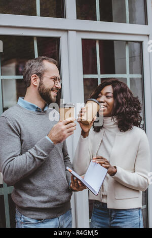 Allegro multietnica i colleghi a discutere di un nuovo progetto e di bere il caffè Foto Stock