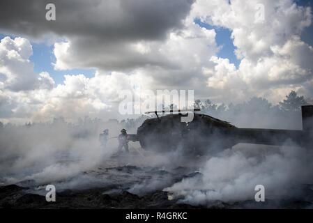 96Ala Test vigili del fuoco incendi di battaglia intorno a una simulazione di elicottero incidente durante un incidente di massa esercizio ottobre 3 a Eglin Air Force Base, Fla. Sistema comunitario di esercitare nel profondo della gamma Eglin compresi 96TW primi responder, 6 Ranger del battaglione di Formazione personale, Okala County primi responder tra gli altri. L'esercizio di valutazione azioni Ranger e la base e le risposte locali sia per la caduta di un fulmine e elicottero incidente. Foto Stock